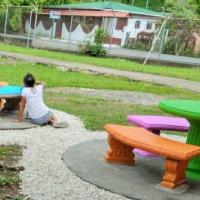 estudiantes de escuela pintando mesas 