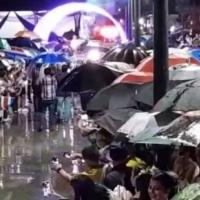Liberianos en la calle con sombrillas 