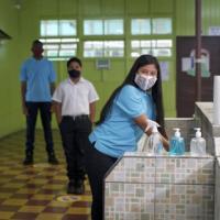 Imagen muestra a estudiantes con lavado de manos y distanciamiento
