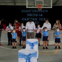 Personas de diferentes edades cortan cinta de bandera