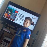Foto muestra estudiante viendo programa televisivo educativo