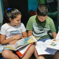 Dos niños con libros y dibujando. 