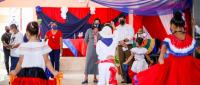 Ministra observa a niñas y niños engalanados en vestidos de colores patrios