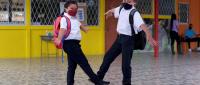 Niños se saludan con el pie en el centro educativo