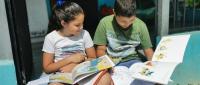 Dos niños con libros y dibujando. 