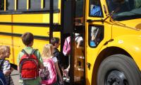 Niños haciendo fila entrando a un bus 