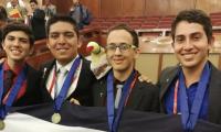 4 estudiantes galardonados con medallas posan sonrientes