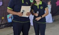 2 estudiantes participan en un festival de inglés como presentadores con micrófono en mano