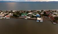 Fotografía aérea de Puntarenas mostrando el mar, casas de habitación a la orilla y muelles
