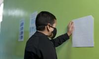 Estudiante con mascarilla leyendo braille