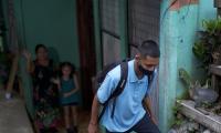 Estudiante con mascarilla saliendo de su casa