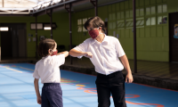 Estudiantes de primaria saludándose con el codo