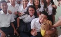 Estudiantes rodeando la mascota de peluche, el perro.