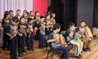 Estudiantes tocando instrumentos y cantando