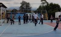 Estudiantes en una cancha de fútbol practicando deporte