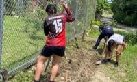 estudiantes quitando zacate