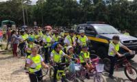 Niños y niñas en bicicleta con sus chalecos reflectivos