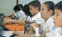 Estudiantes con objetos de laboratorio y robótica.