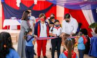 Grupo de personas cortan una cinta con los colores de la bandera.