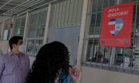 al fondo se ve el presidente y una joven le muestra un mensaje contra la homofob