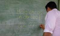 Presidente escribe en la pizarra
