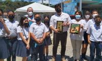 Niñas, niños y autoridades de Gobierno posan para una foto y muestran obsequios 