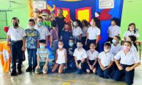 Grupo de niños y niñas posan. Al fondo un mural 