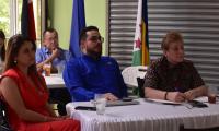 Tres personas, dos mujeres y un hombre sentados escuchando